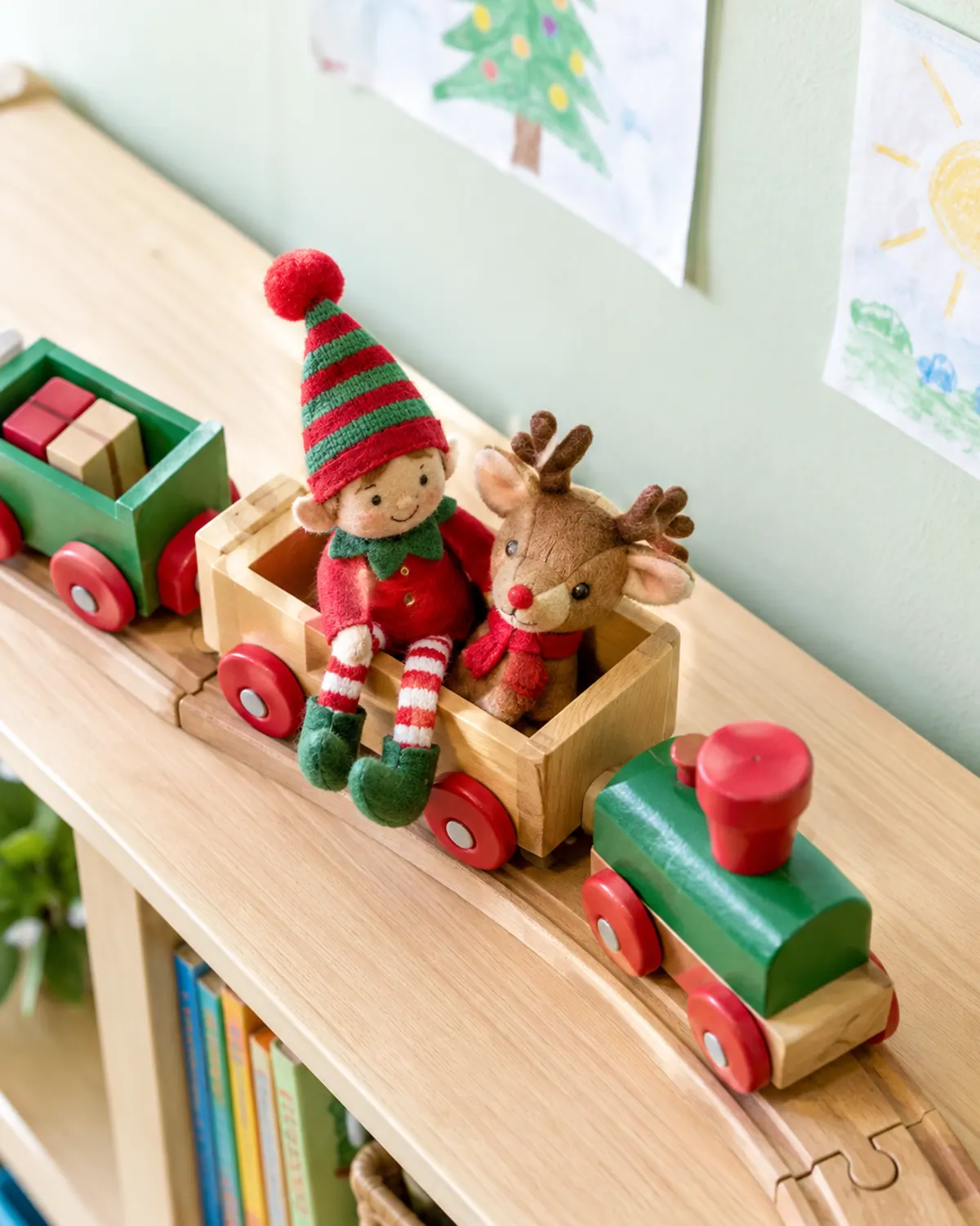 A felt elf doll riding a wooden toy train on top of a tall playroom shelf with a plush reindeer passenger